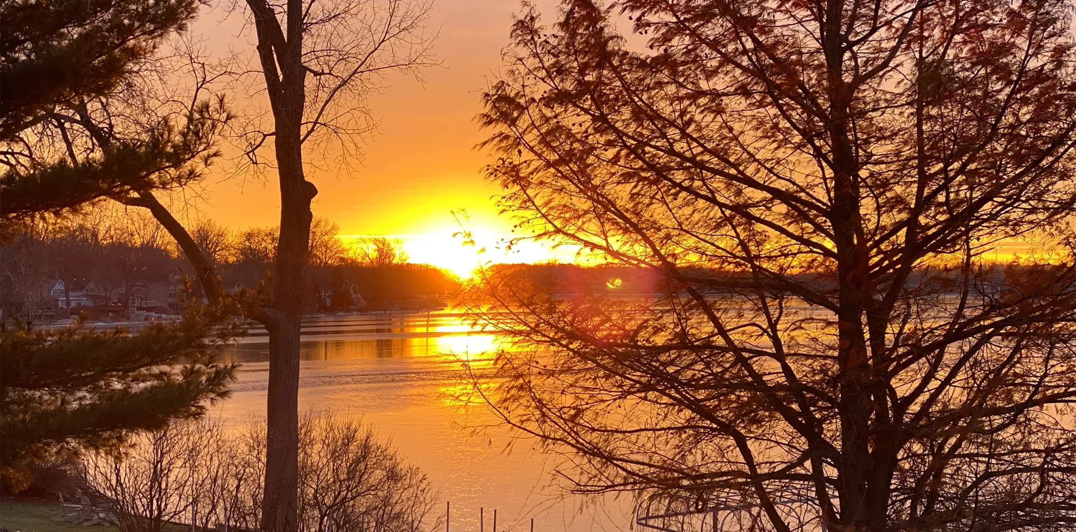 Sunset over a lake viewed through trees