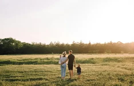 Parents and children walking through a meadow