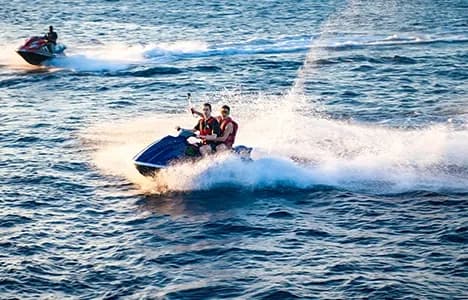 People riding personal watercraft on a lake