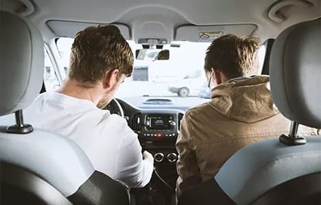 Two young men seated in a car
